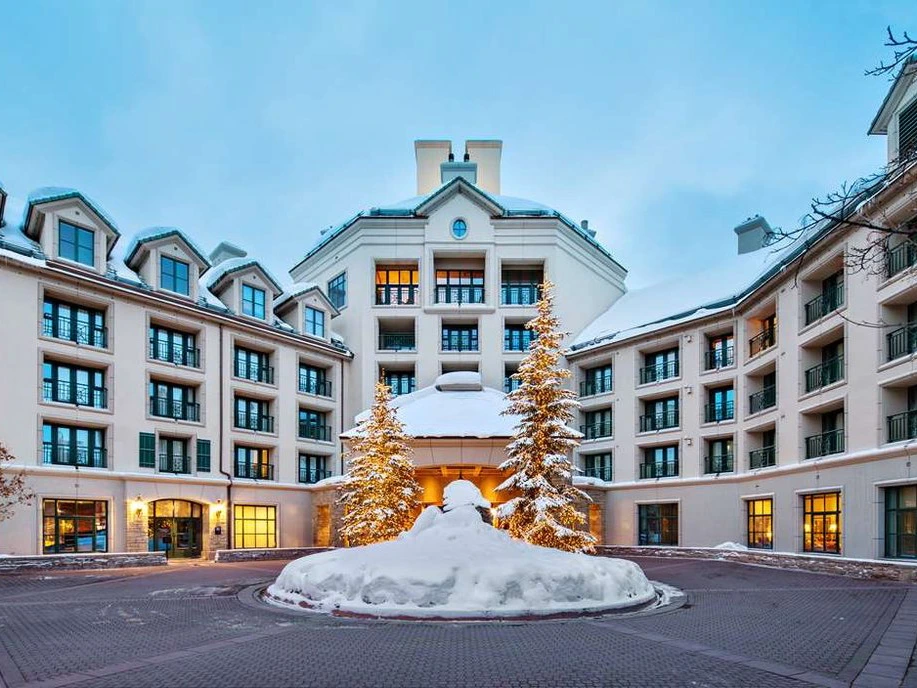 Snowy exterior of Hyatt Residence Club Beaver Creek, an Interval International destination, with lit trees.