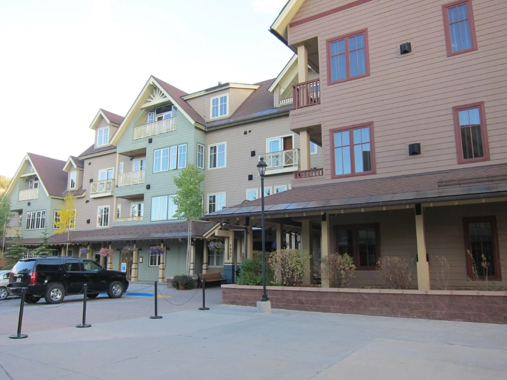 Ground-level view of the colorful exterior and covered walkways at Hyatt Main Street Station, a popular base for summer getaways in Colorado.