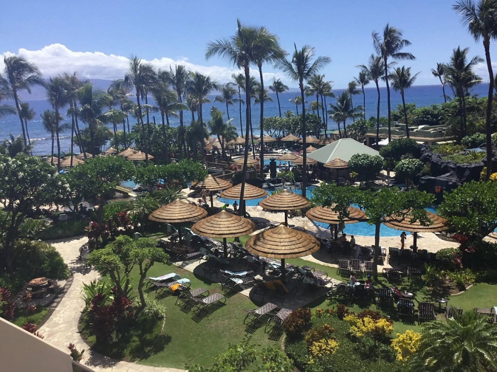 Sunny Marriott's Maui Ocean Club resort with palm trees, umbrellas, and a pool by the beach.
