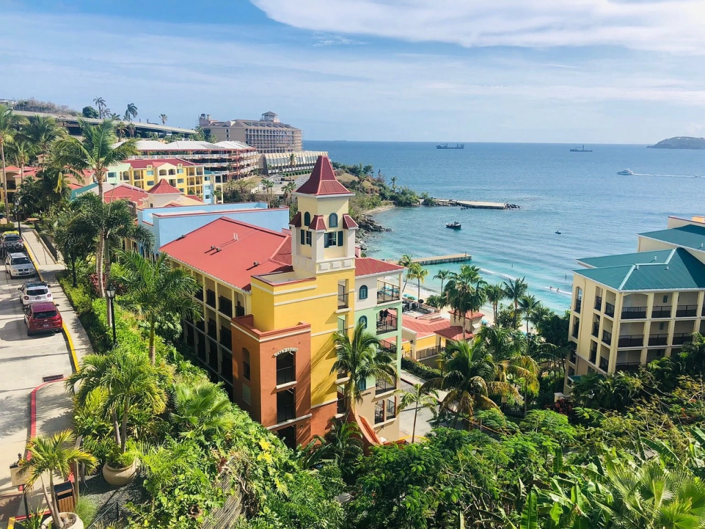 Aerial view of Marriott's Frenchmans Cove, featuring colorful buildings near a beach with palm trees and boats on blue water.