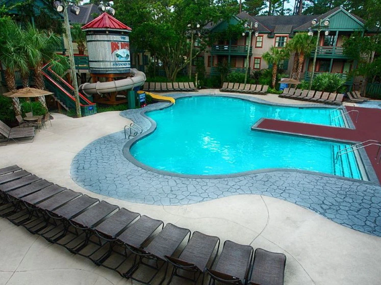 A summer vacation at the Big Dipper pool featuring a water slide and lounge chairs.