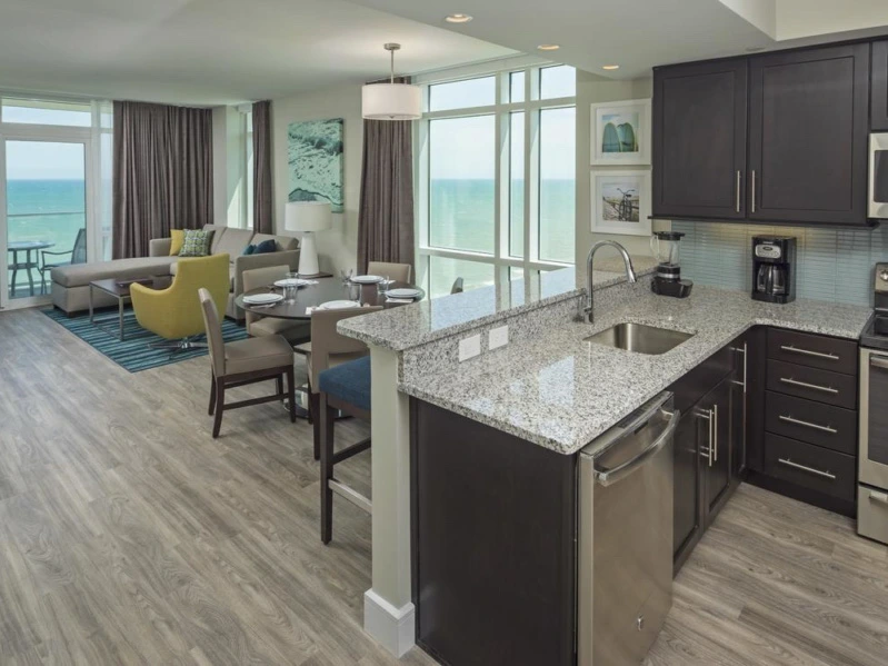 Modern suite kitchen with granite counters and ocean view living room at a timeshare in Myrtle Beach.