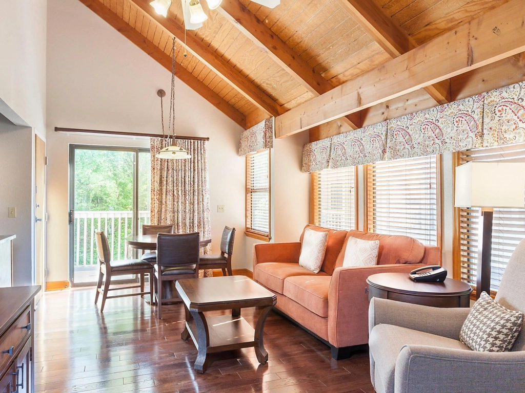 Vaulted wood ceilings highlight this cozy living space and dining area at a timeshare in gatlinburg.