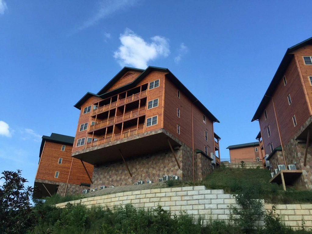 Exterior view of the rustic, log-cabin style buildings at this timeshare in gatlinburg, set on a hillside.