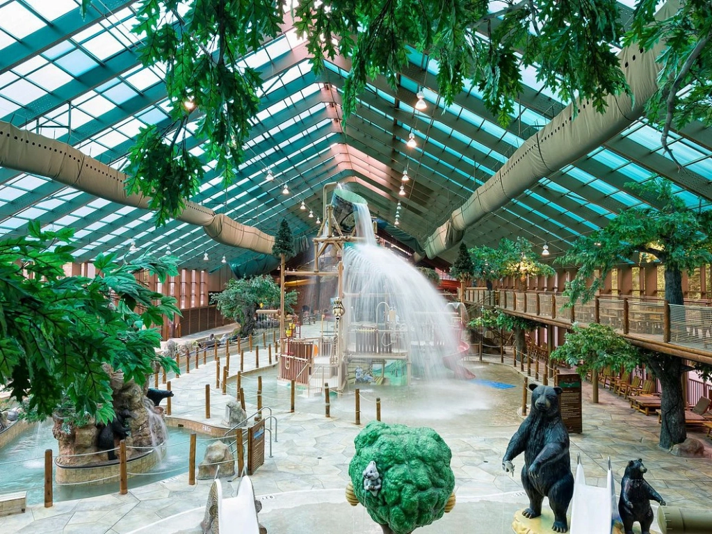 Exciting indoor water park featuring a large splash bucket, pool, and bear statues at a timeshare in gatlinburg.
