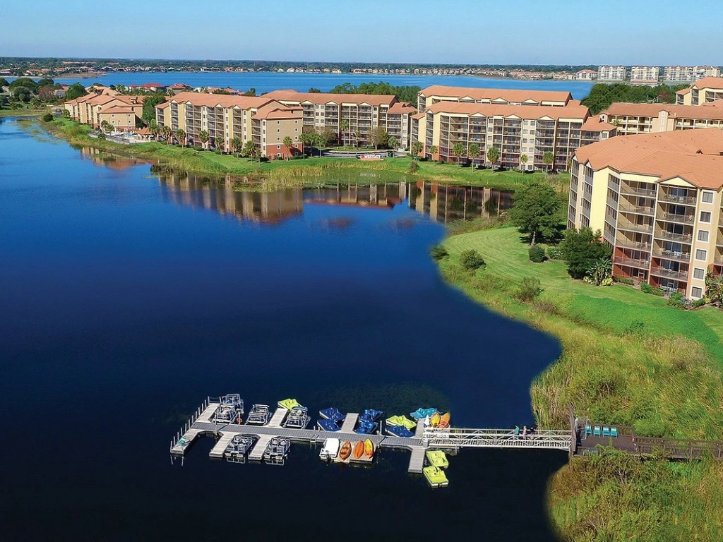 Aerial view of Westgate Lakes Resort and Spa showing large waterfront buildings, a lake, and a dock with paddle boats.