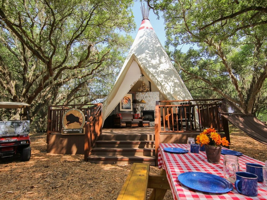 Experience a unique summer vacation in a luxury glamping teepee with a wooden deck.