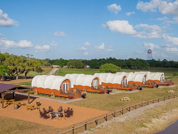 Row of luxury covered Conestoga wagons perfect for a summer vacation glamping trip.