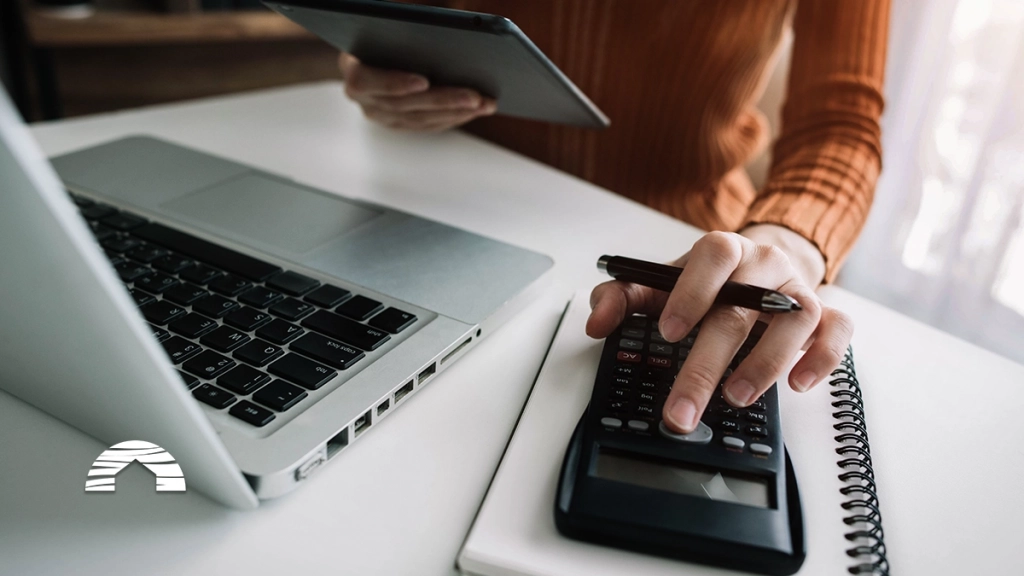 Person using a calculator, tablet, and laptop to figure out: do you pay closing costs on timeshare resales?