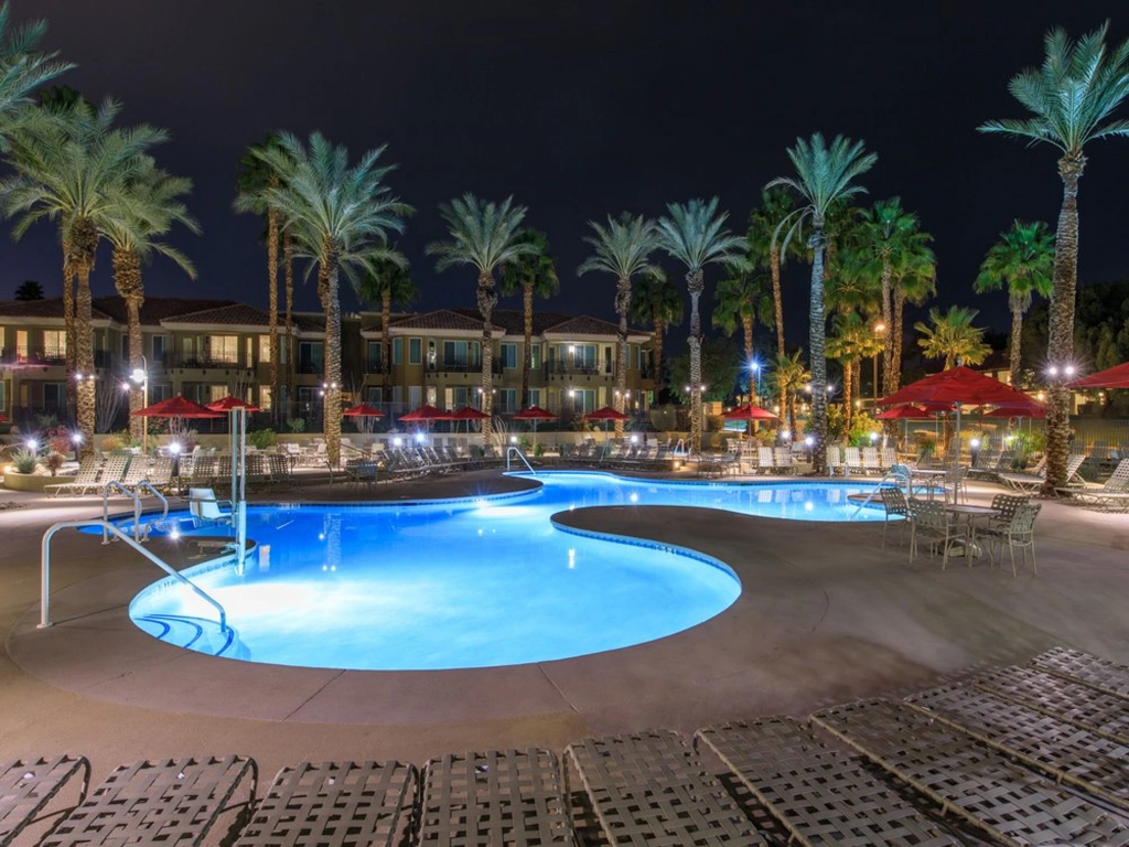 Illuminated outdoor pool and palm trees at night at Marriott's Desert Springs Villas.