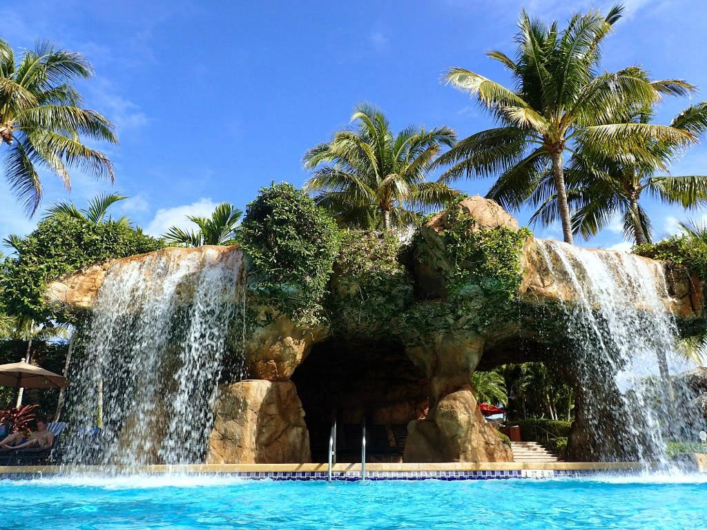 Guests enjoy a tropical swimming pool featuring a large rock waterfall at a Hyatt Vacation Club resort in Bonita Springs.