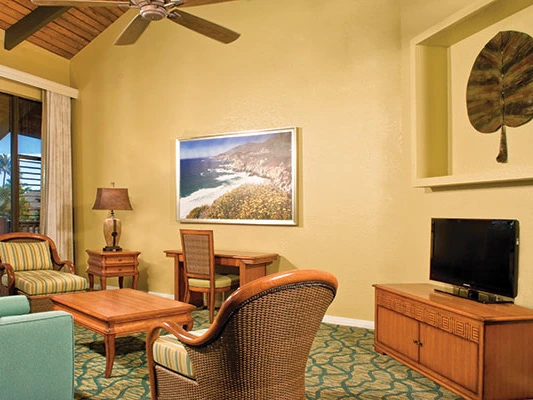 Bright living room with wicker furniture, large coastal wall art, and flat-screen TV at KaEoKai.