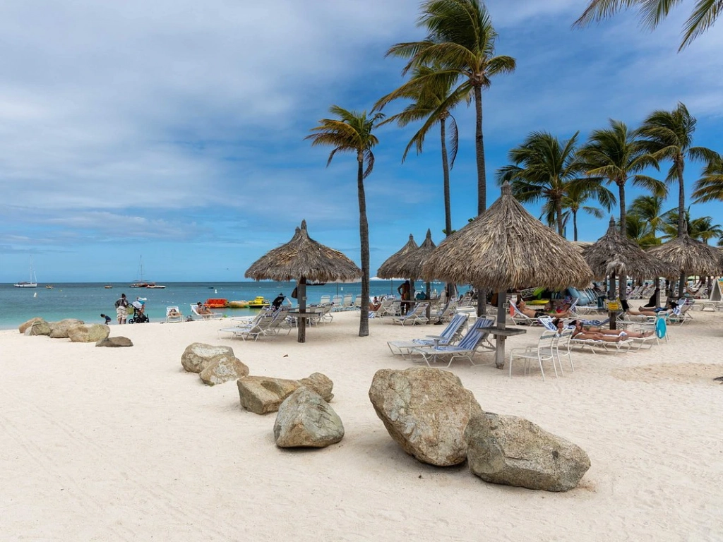 Relax under thatched umbrellas on the beach at Marriott's Aruba Surf Club to debate fractional ownership vs timeshare.