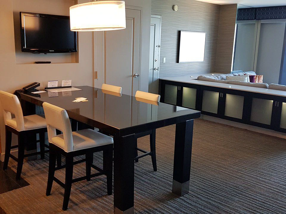 Spacious suite living area with a large dining table at Elara Las Vegas.