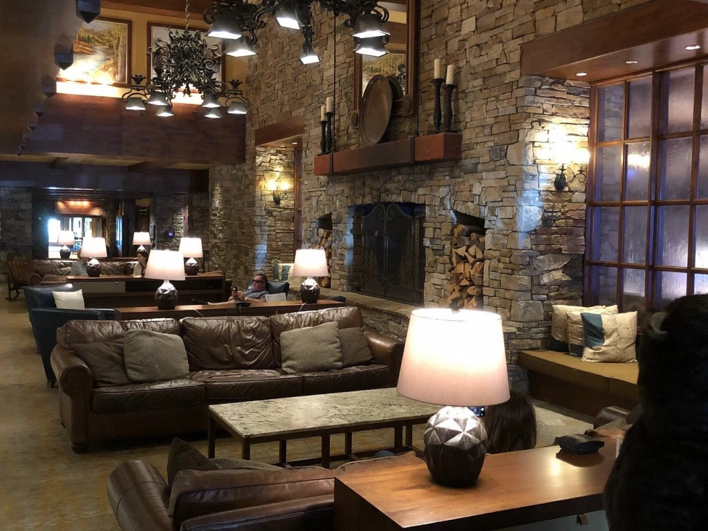 Cozy leather couches sit near a large stone fireplace inside the rustic lobby at the Hyatt Regency Lake Tahoe.