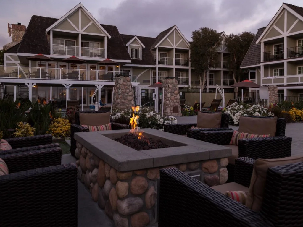 Wicker chairs surrounding a stone fire pit at dusk at a San Diego timeshare.