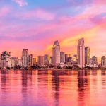 San Diego skyline at sunset reflected in calm bay waters, a popular destination for timeshare in san diego ownership
