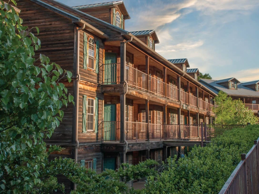 Rustic multi-story wooden building with green shutters and balconies at The Villages Resort.