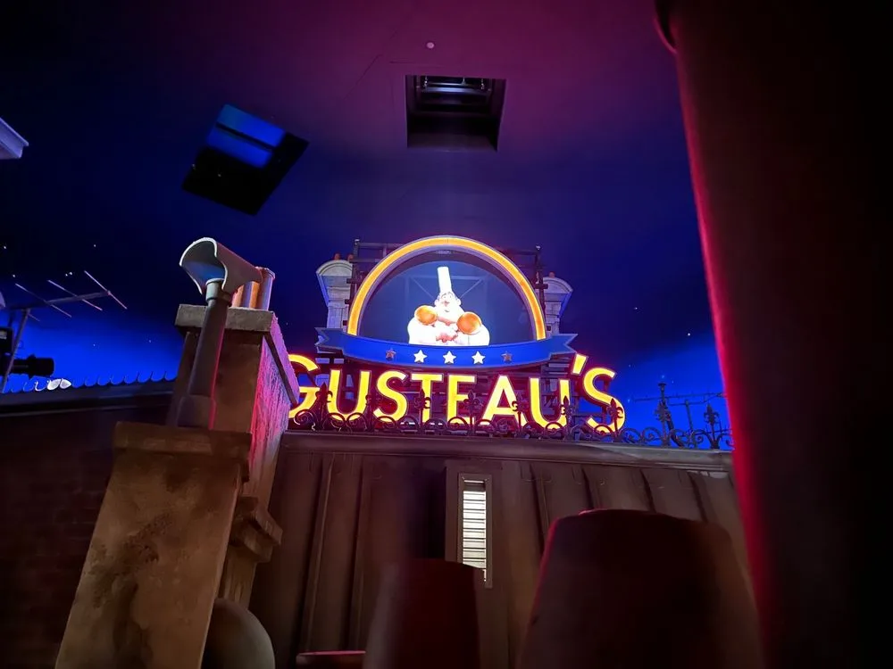 Gusteau's neon sign glowing in a darkened queue at one of the most beloved Epcot rides.